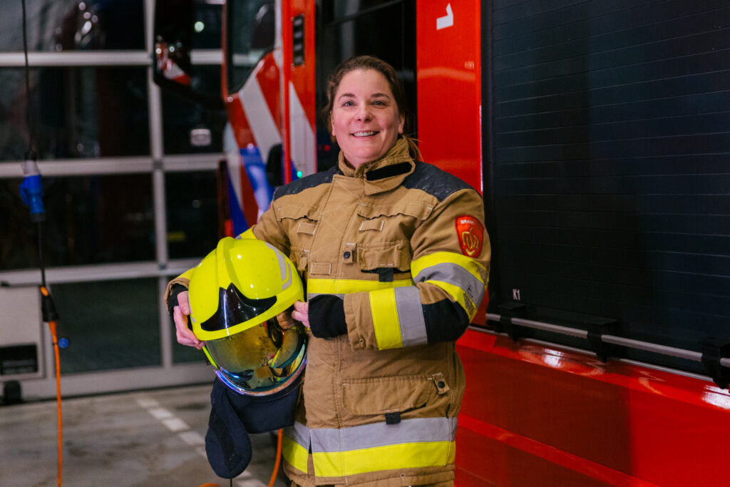 Twee brandweervrijwilligers komen in de kazerne aan en kleden zich om.