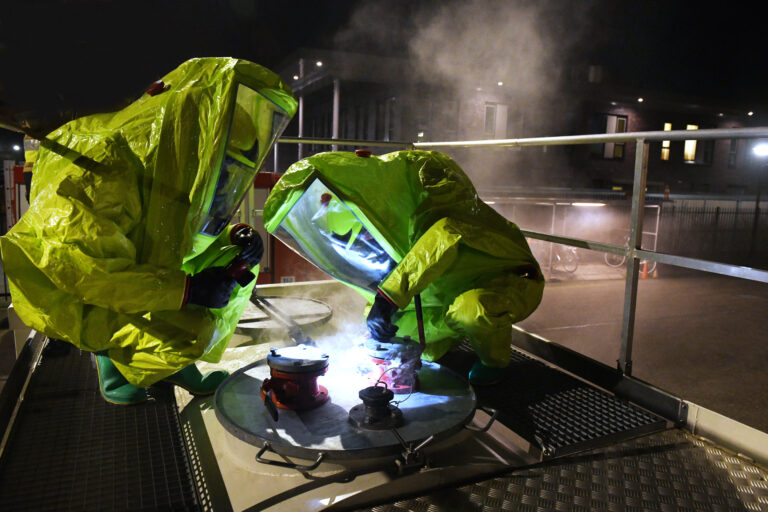 Twee brandweermensen met een gaspak aan bij een incident met een gevaarlijke stof